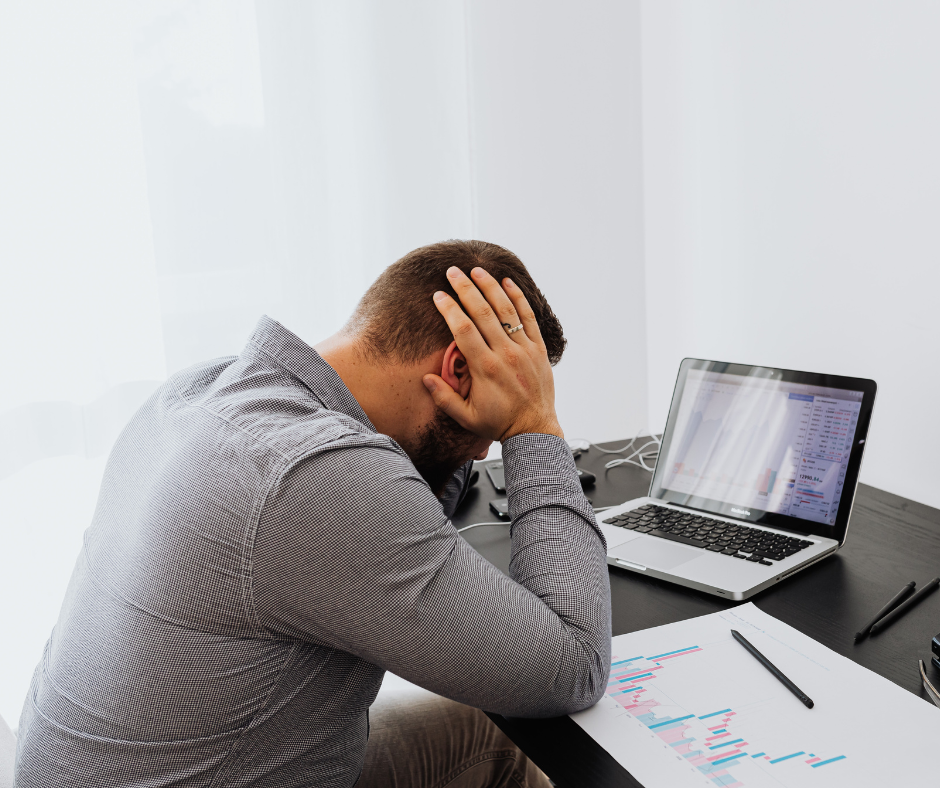 stressed man at desk with hands in hair